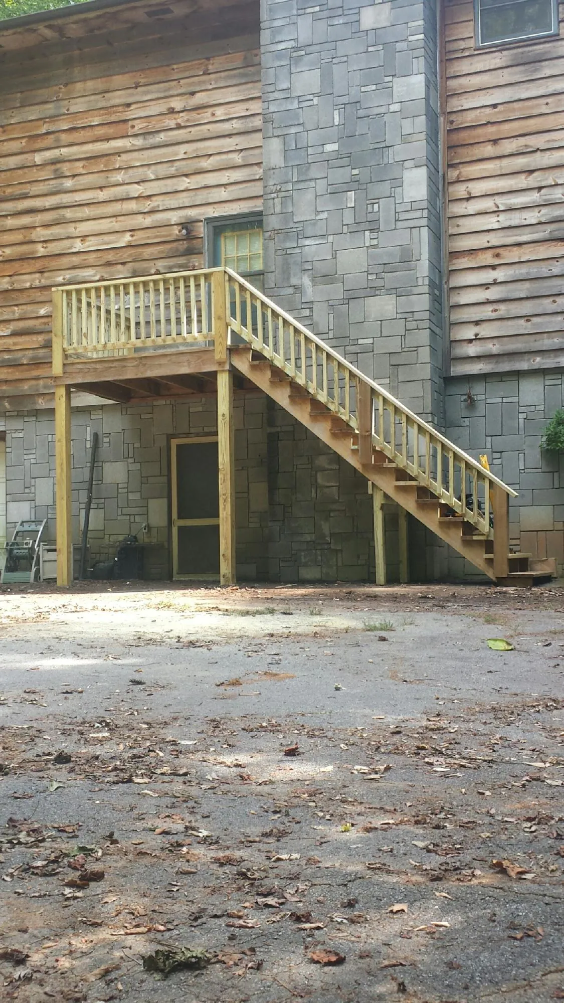 New pressure treated deck and stair landing on a log home in Spotswood